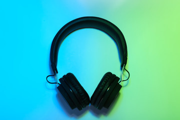 Stylish headphones on color background, top view
