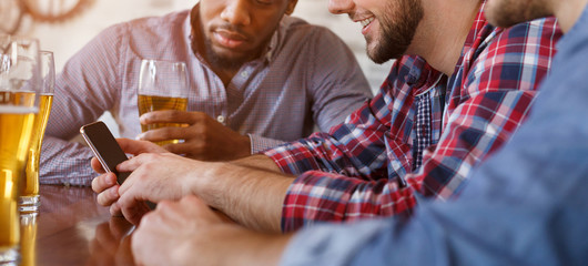 Man Showing New App On Smartphone, Resting In Bar With Friends