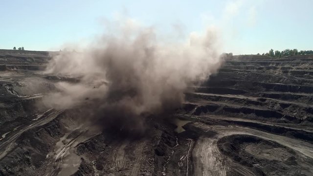 Explosion at open mine. Detonation rocks in quarry Mining. Aerial Powerful explosion on open pit mine. View from above on the effects of the explosion