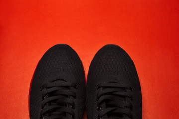 Sport black sneakers isolated on red background