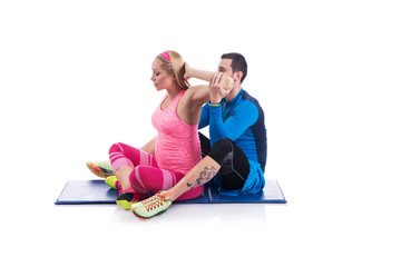 Happy young couple doing exercise in pair for pregnancy on the white background.