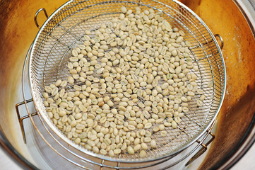 Homemade roast of green coffee beans in aerogrill. Top view