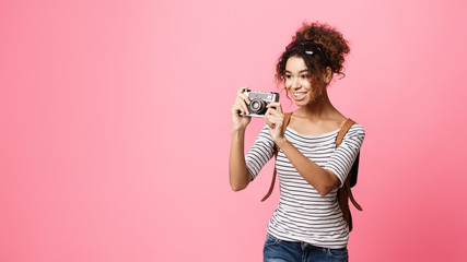 Obraz premium African-American Traveller Taking Photo On Retro Camera