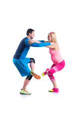 Happy young couple doing exercise in pair for pregnancy on the white background.