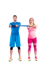 Happy young couple doing exercise in pair with elastic rubber for pregnancy on the white background.