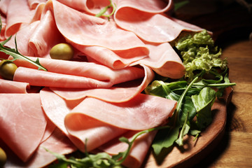 Sliced ham on wooden background. Fresh prosciutto. Pork ham proscuitto sliced.