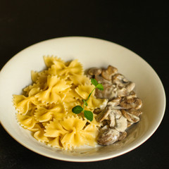 pasta farfalle with julienne mushrooms (fresh dish). food background. top