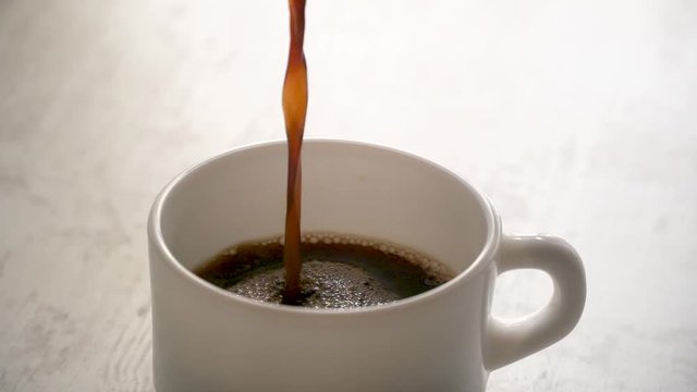 verse caf&eacute; dans une tasse en slow motion