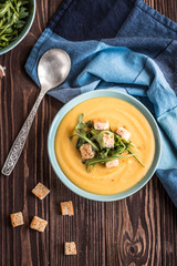 Pea soup with with croutons and greens on a wooden background. Pea cream soup.