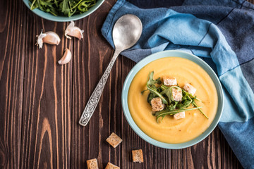Pea soup with with croutons and greens on a wooden background. Pea cream soup.