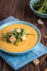 Pea soup with with croutons and greens on a wooden background. Pea cream soup.
