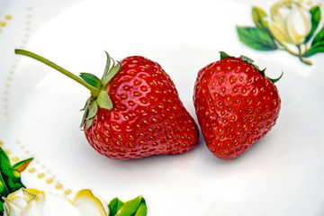 Berries ripe strawberries on a plate close-up, top view.