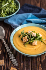 Pea soup with with croutons and greens on a wooden background. Pea cream soup.