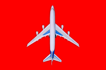 Passenger aircraft on a red background. Summer holidays and air travel concept. Tourism and travel background. Buying or booking online tickets. Business flights