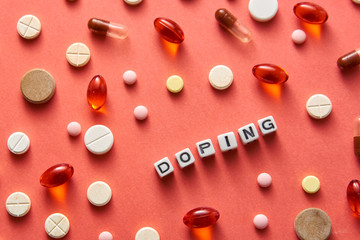 Black and white title DOPING from white cubes on the table with tablets on coral background