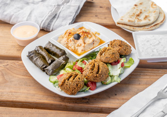 Falafel platter with hummus and dolmas served at a Greek restaurant.