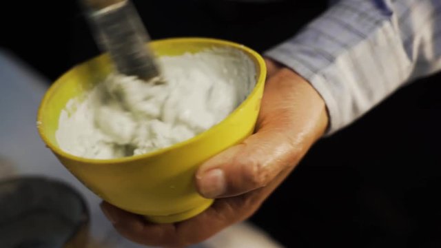 Dental mixture of plaster of paris for denture flasking procedure, close up shot