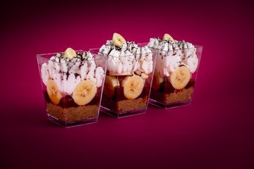 Cup of banana banoffee on red Background.