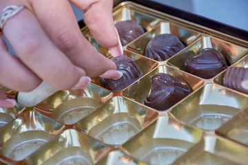 girl with a manicure take candy out of the box