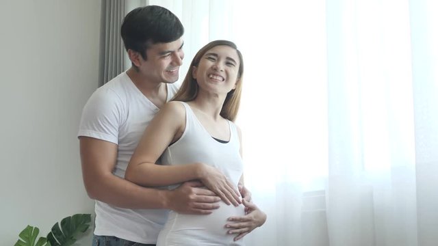 Pregnant woman with her husband in bedroom