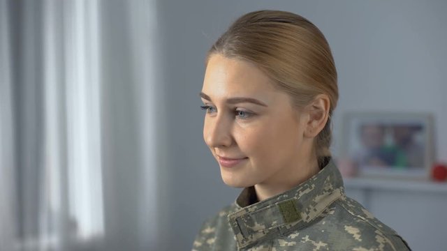 Joyful soldier woman in military uniform looking into camera, independence day