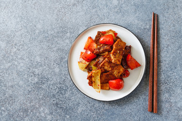 Szechuan traditional dish Hui Guo Rou, spicy roasted pork with leek and bell pepper. Portion size, top view.