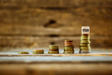 Steuer Euro Münzen gestapelt wie eine Treppe mit Würfel