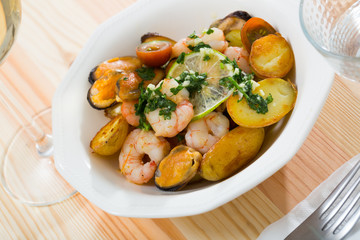 Stewed slices of potato with seafood