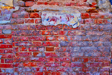 Worn brick wall of bright red-pink color