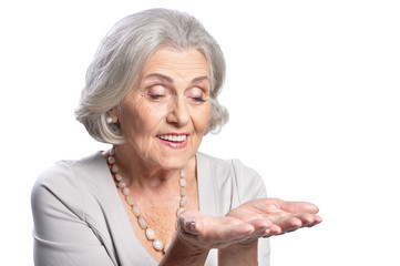 Portrait of beautiful senior woman looking at her palm isolated