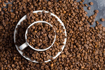 White Cup of coffee with coffee beans . Scattered coffee beans