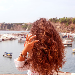 beautiful curly girl posing in a panoramic point of Procida's Island