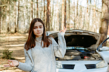 Young girl near a broken car