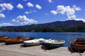 Wooden boats on the pier on the background of the castle on Lake Bled. Beautiful view, nature, calm