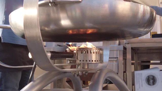 Fiamma di un fornello a gas con grande padella wok in alluminio di un ristorante asiatico Giapponese per la cottura dei cibi. Video al rallentatore.