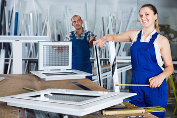 Obraz premium Girl working in workshop for assembling plastic windows