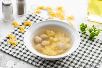 Chicken bouillon with meatballs and farfalle