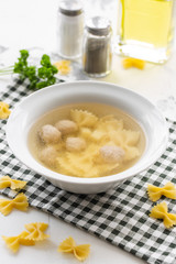 Chicken bouillon with meatballs and farfalle