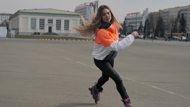 Beautiful girl on roller skates in skate park. Young woman riding skates in street