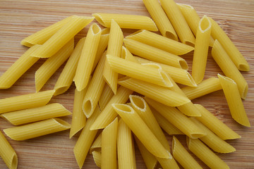 Penne pasta on a wooden board