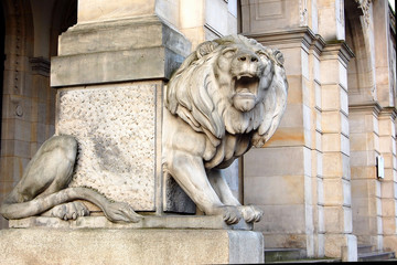 roaring lion at the base of the column at the entrance to the building