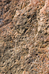 Background of granite. Texture of granite stone. Pattern of roughened surface. Texture of brown stone