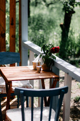 standing in the street on a wooden table vase with a bouquet of red peonies, closeup