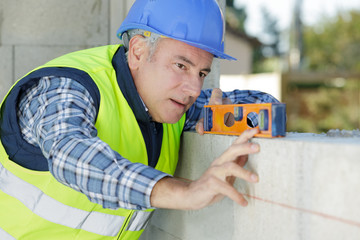 man measuring plane using a spirit level