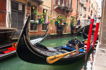 Fototapeta na wymiar Traditional gondola in venetian water canal in Venice, Italy. Black gondola in Venezia