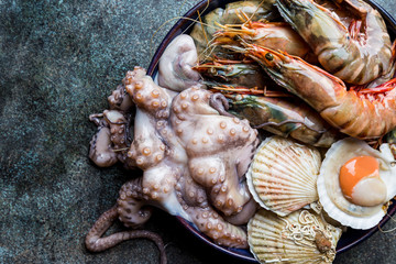 Assortment of seafood with raw fresh octopus, scallops and prawns, as an gourmet dinner background