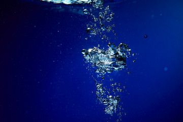 Ice cubes falling into the water