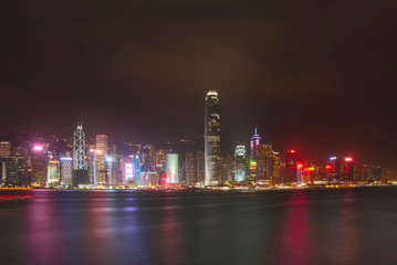 Fototapeta premium The illuminated skyscrapers along the waterfront at Victoria Harbour in Hong Kong
