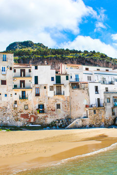Beautiful old houses overlooking the Tyrrhenian sea in Cefalu, Sicily, Italy. Captured on vertical picture with rock behind the historical city. Cefalu is a popular vacation destination