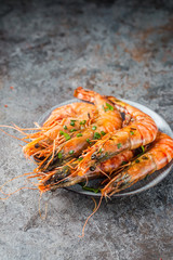 Giant fresh Tiger Prawns on plate over dark stone background